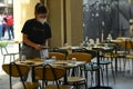 Female waiter setting terrace table of restaurant