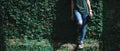 Female waiting legs jeans leaning against a wall