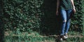 Female waiting legs jeans leaning against a wall