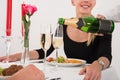 Female Waitress Pouring Champagne Into Glass For Couple Royalty Free Stock Photo