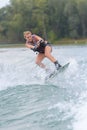 Female wakeboarder making tricks on lake Royalty Free Stock Photo