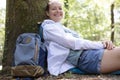 female walker resting against tree