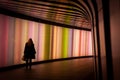 Female walking in the colorful lights of the tunnel in Kings Cross Station, London, UK Royalty Free Stock Photo