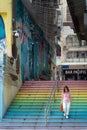 Female walking down the colorful stairs in Hong Kong