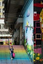 Female walking down the colorful stairs in Hong Kong