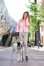 Female walking her dog outdoors and talking on mobile phone