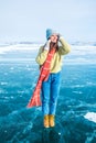 Female wanderer dressed in fashionable hat and mittens and scarf standing outdoors