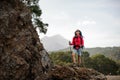 Female wanderer posing on top of rock