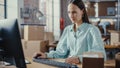 Female Warehouse Inventory Manager Using Desktop Computer, Preparing Cardboard Box Order for Royalty Free Stock Photo