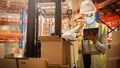 Female Warehouse Inventory Manager Wearing Face Mask for Safety, Using Digital Tablet Computer, Ch Royalty Free Stock Photo