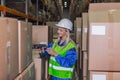 Female warehouse worker using scanner in storehouse