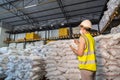 A Female warehouse worker wear a mask inspecting chemical products in alum or chemical warehouse storage. International export