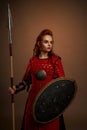 Female warrior keeping spear and shield and posing Royalty Free Stock Photo