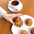 Female weakness. Morning coffee and cake for dessert. Woman holds muffins with raisins. Sweet pastries, dessert. Food