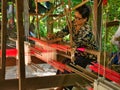 A female weaver producing silk fabric on a traditional hand loom on Silk Island / Koh Dach near Phnom Penh in Cambodia