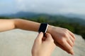 Female white hands using smart watch, mountains in background. Royalty Free Stock Photo