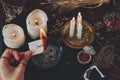 Female wiccan witch holding a burning peace of paper in her hand. White paper with words `I wish` written on it