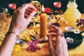 Female wiccan witch wearing vintage jewelry lighting a yellow candle on her Litha midsummer Sabbat Solstice celebration altar Royalty Free Stock Photo