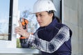 Female window fitter using cordless screwdriver