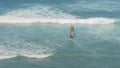 A female windsurfer sails at diamond head