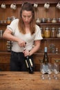 A female wine taster opening a bottle of red wine