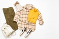 Female winter or autumn stylish clothing set. Plaid checkered shirt, yellow sweater, green corduroy trousers, hat with pompom,