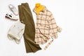 Female winter or autumn stylish clothing set. Plaid checkered shirt, yellow sweater, green corduroy trousers, sneakers and