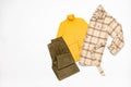 Female winter or autumn stylish clothing set. Plaid checkered shirt, yellow sweater, green corduroy trousers. Trendy fashionable