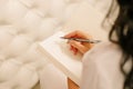 female woman hand holding notepad and writing with pen. Pencil on paper  metal parker. Light background leather white. Close-up Royalty Free Stock Photo