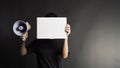 Female or woman hands is holding blank A4 white paper and megaphone on black background.she wear black t shirt Royalty Free Stock Photo