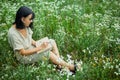 Female woman with pen writing or painting, handwriting on notebook on flower blooming meadow