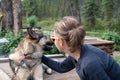 Female woman traveler spends time and pets an Alaskan Husky Sled Dog