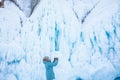 Female wonderer shooting video on smartphone of a big ice rock