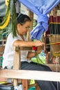 Female worker behind the machine. Fabricates beautiful tapestries.Thailand