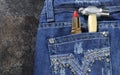 Female worker blue jeans with rhinestone decoration and red lipstick and hammer.