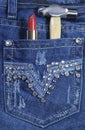 Female worker blue jeans with rhinestone decoration and red lipstick and hammer.