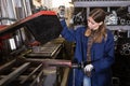 Female worker cuts metal profile pipe on a band saw Royalty Free Stock Photo