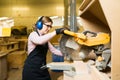 Female worker cutting a wooden board with a bench saw Royalty Free Stock Photo