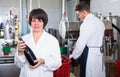 Female demonstrating wine bottle Royalty Free Stock Photo