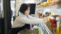 Female worker with Down syndrome restocking vegetables from the box