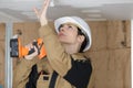 Female worker drilling ceiling Royalty Free Stock Photo