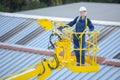female worker elevated in cherry picker bucker Royalty Free Stock Photo