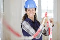 Female worker erecting exclusion chain in renovation property