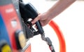 Female worker hand holding nozzle fuel fill oil into car tank at pump gas station Royalty Free Stock Photo