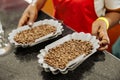 Female worker holding bowls of coffee beans for tasting