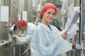 Female worker holding clipboard in factory