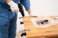 Female worker Installing a furniture door hinge, close-up. Furniture assembling Royalty Free Stock Photo