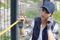female worker measuring fence Royalty Free Stock Photo