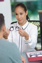 female worker offering glasses in optics store Royalty Free Stock Photo