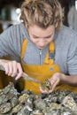 female worker opening french oysters